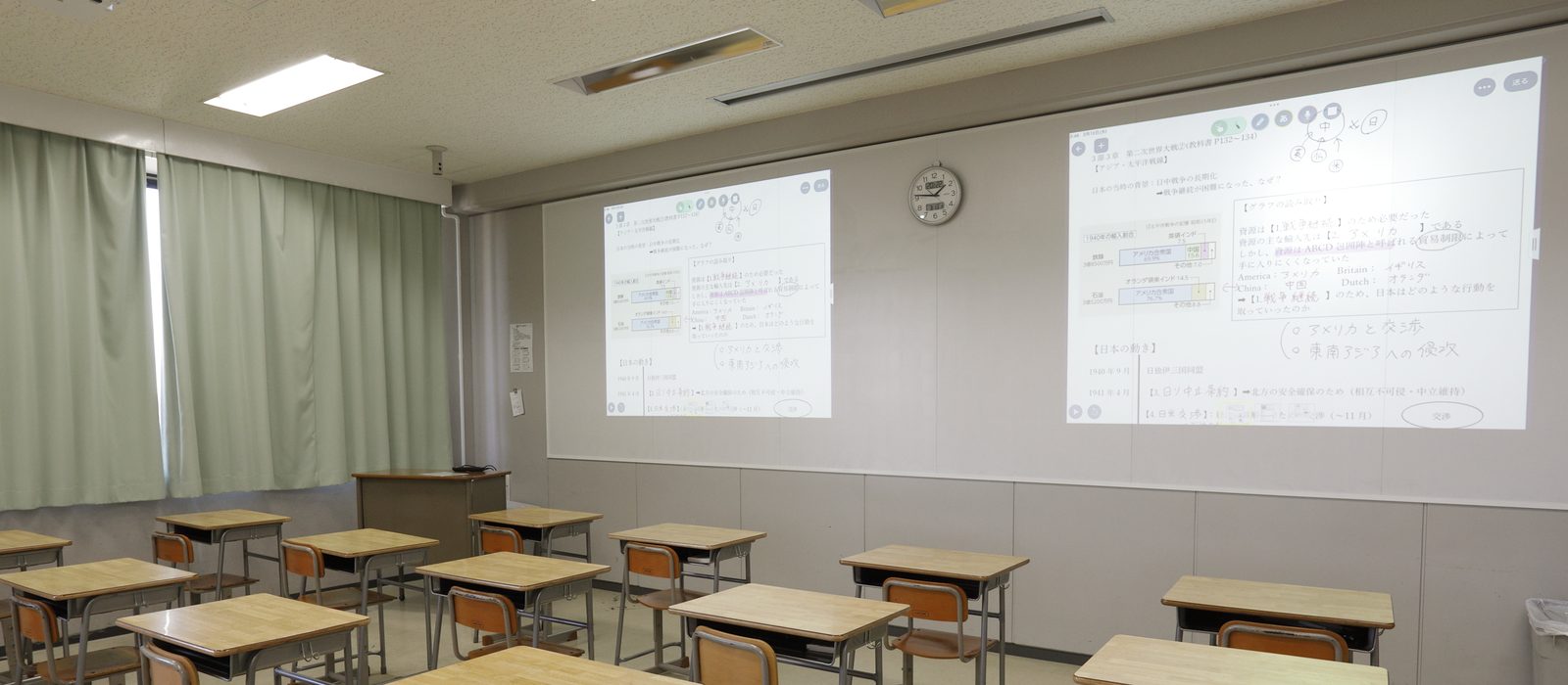 黒板のない教室。前面の大型ホワイトボードに、2機のプロジェクターで2つの画面を投影している